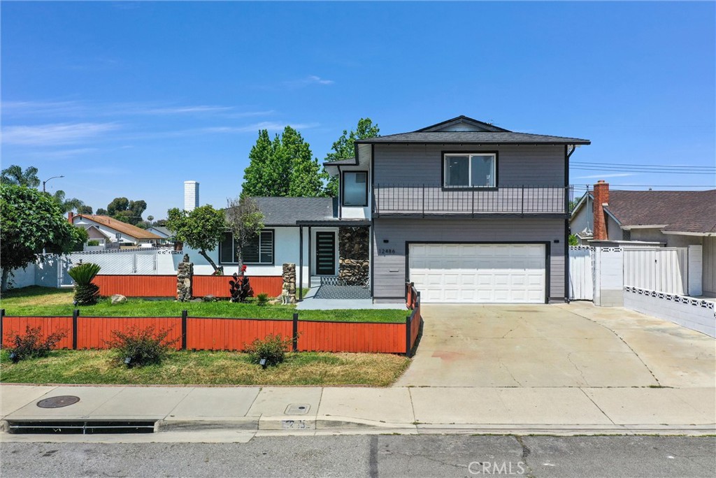 a front view of a house with a yard and potted plants