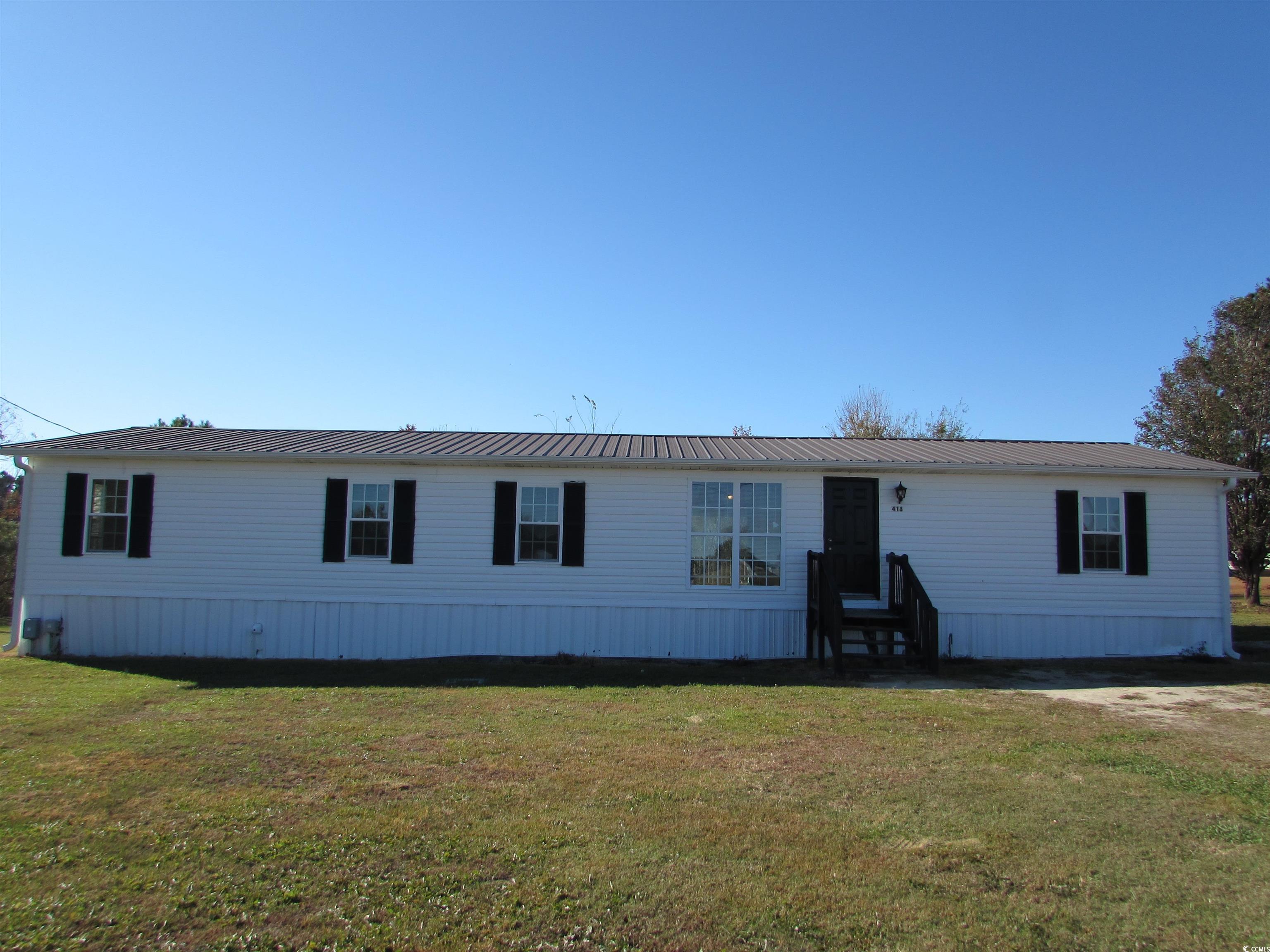 Manufactured home featuring a front yard and metal