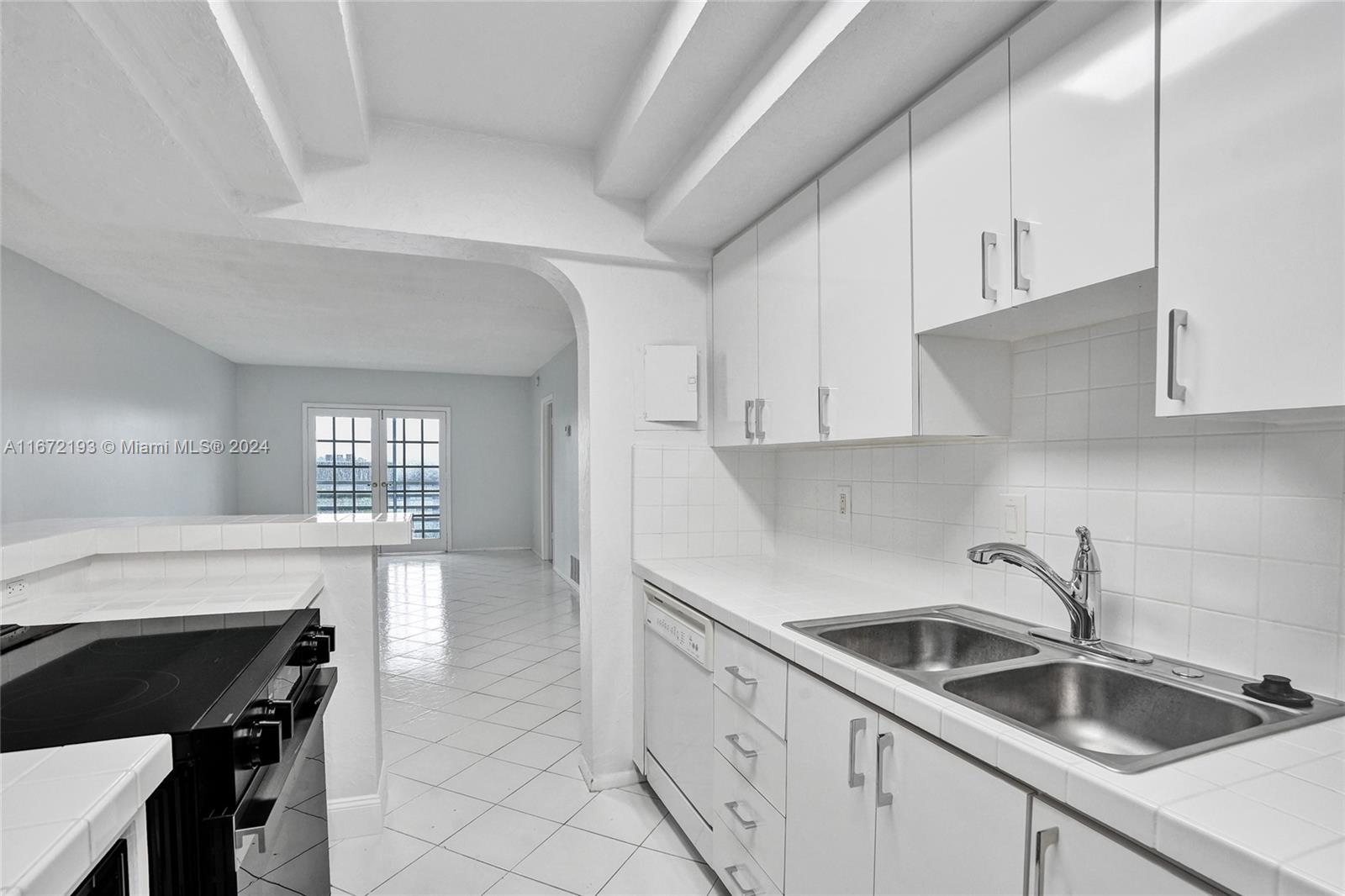 a kitchen with granite countertop white cabinets and white appliances