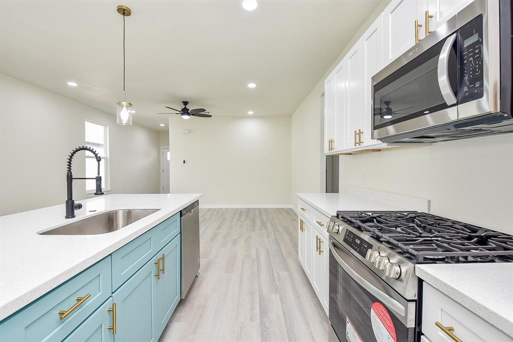 a kitchen with kitchen island granite countertop a sink stainless steel appliances and cabinets