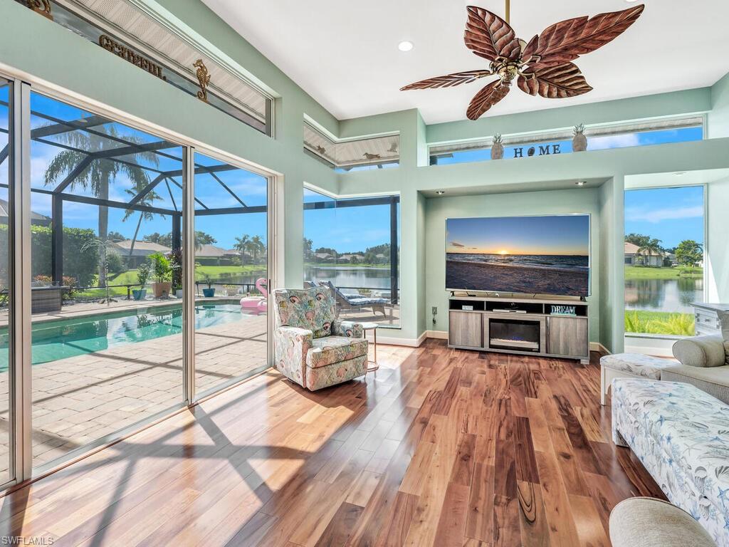 a living room with furniture a flat screen tv and a floor to ceiling window