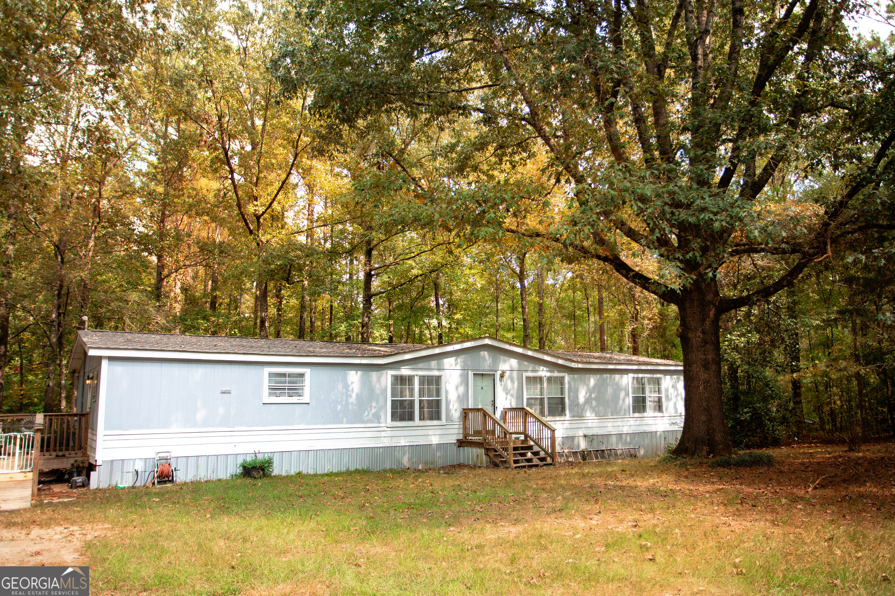 a front view of a house with a yard balcony and a tree