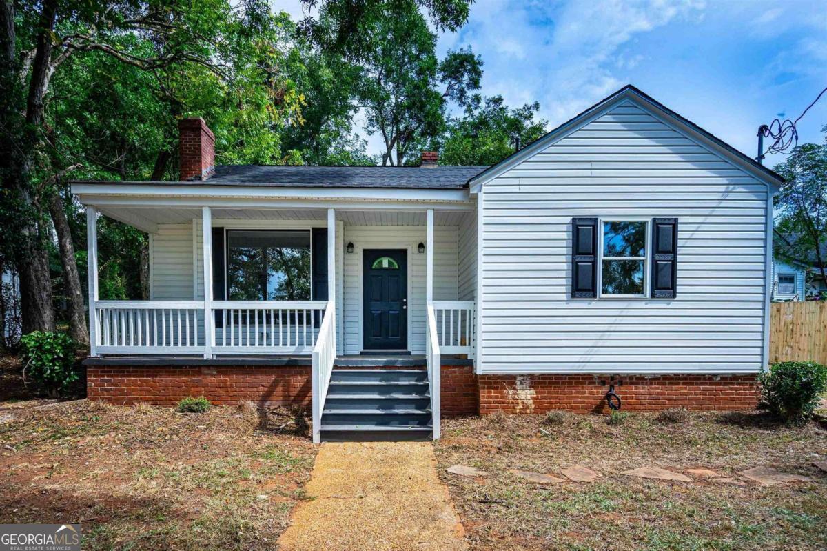 a view of a house with a yard and a porch