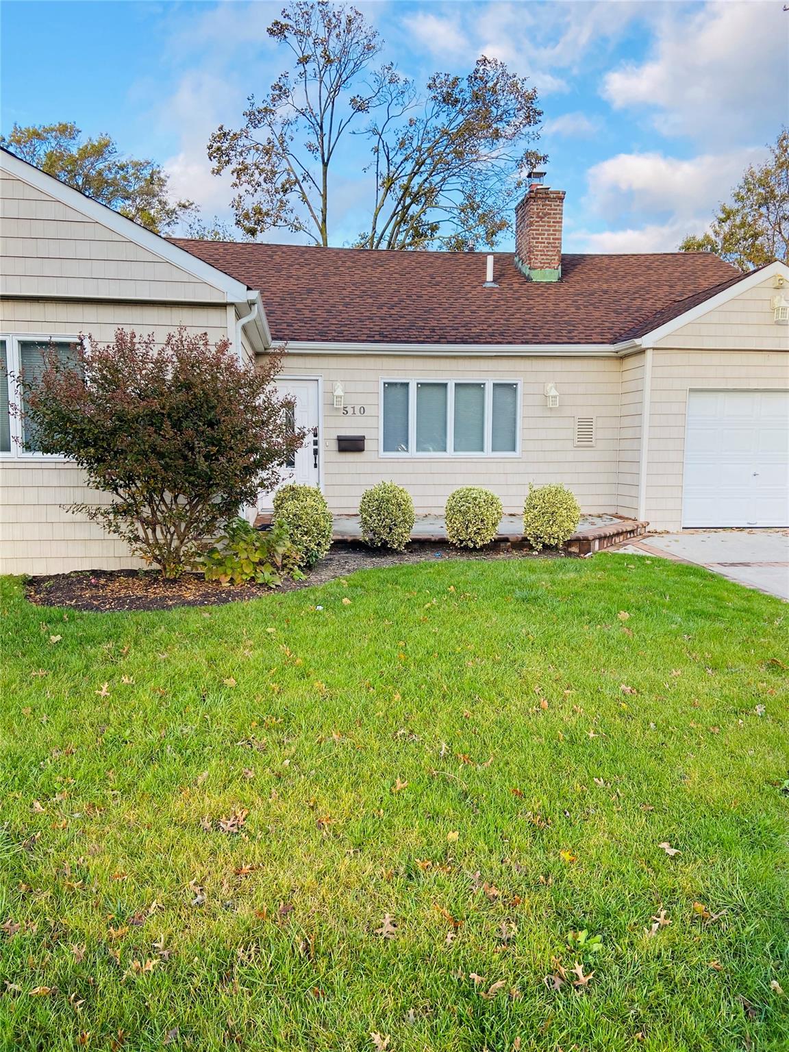 a front view of a house with a garden and yard