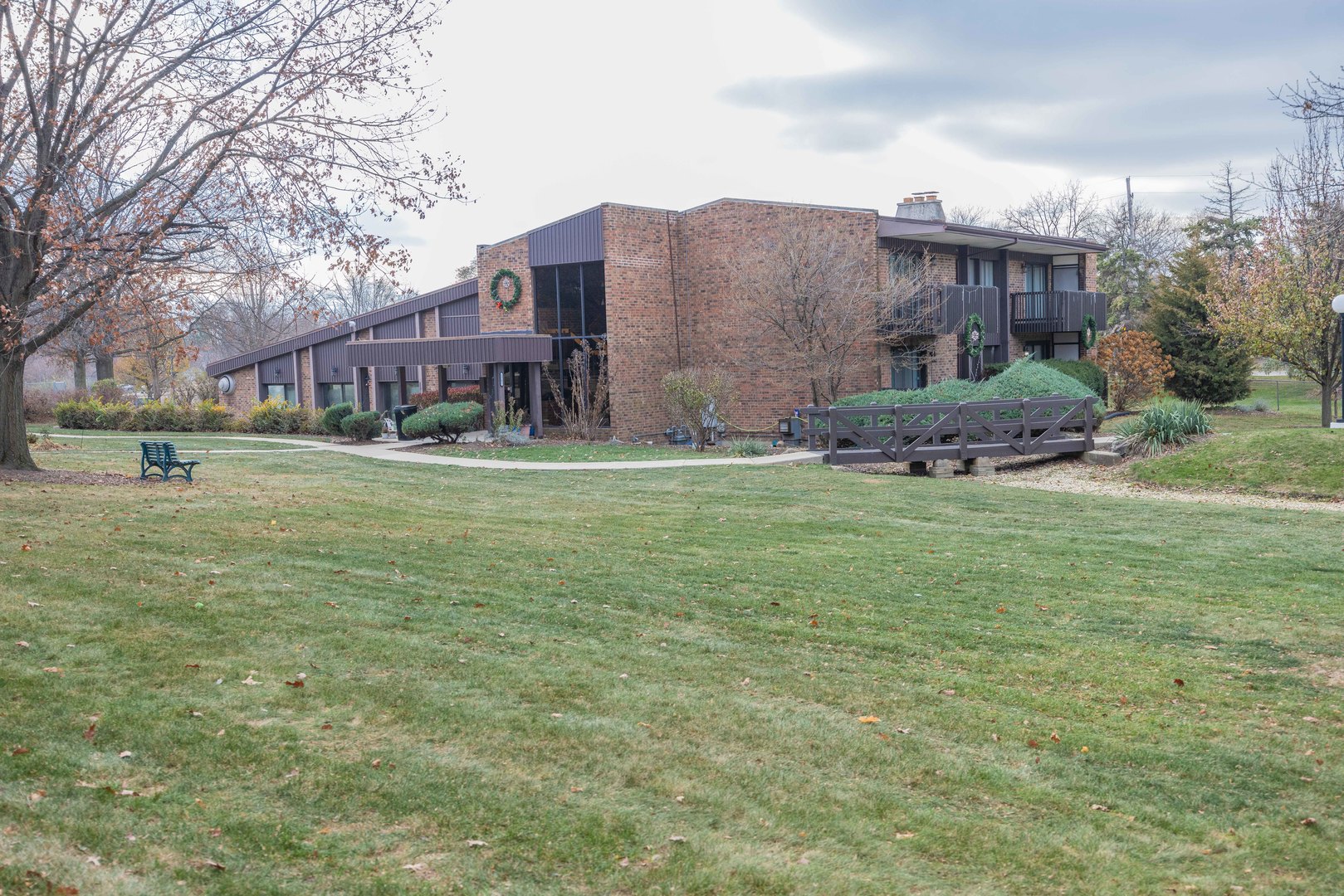 a view of a big house with a big yard and large trees