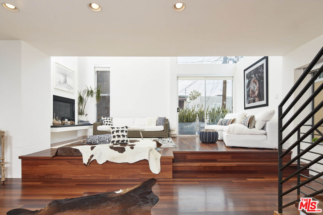 a living room with couches bookshelf and a flat screen tv