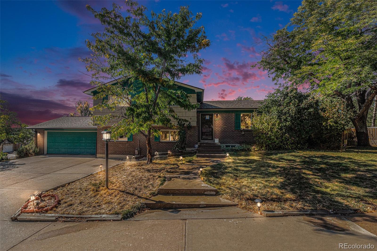 a front view of a house with a yard tree and outdoor seating