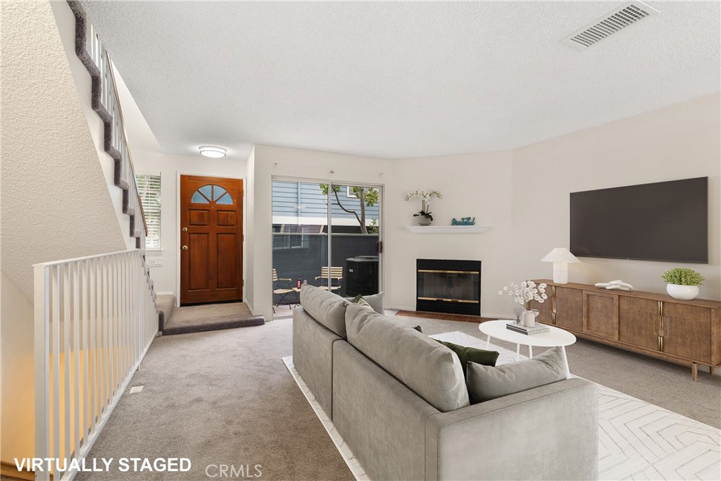 a living room with furniture a flat screen tv and a fireplace