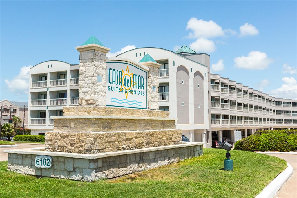 a front view of a building with a garden and plants