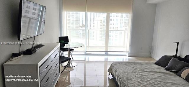 a bedroom with a bed and a flat tv screen next to a window