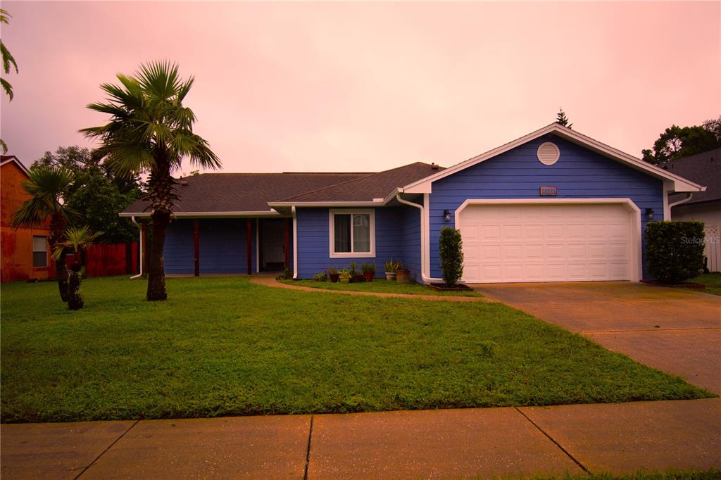 a front view of a house with a garden and yard