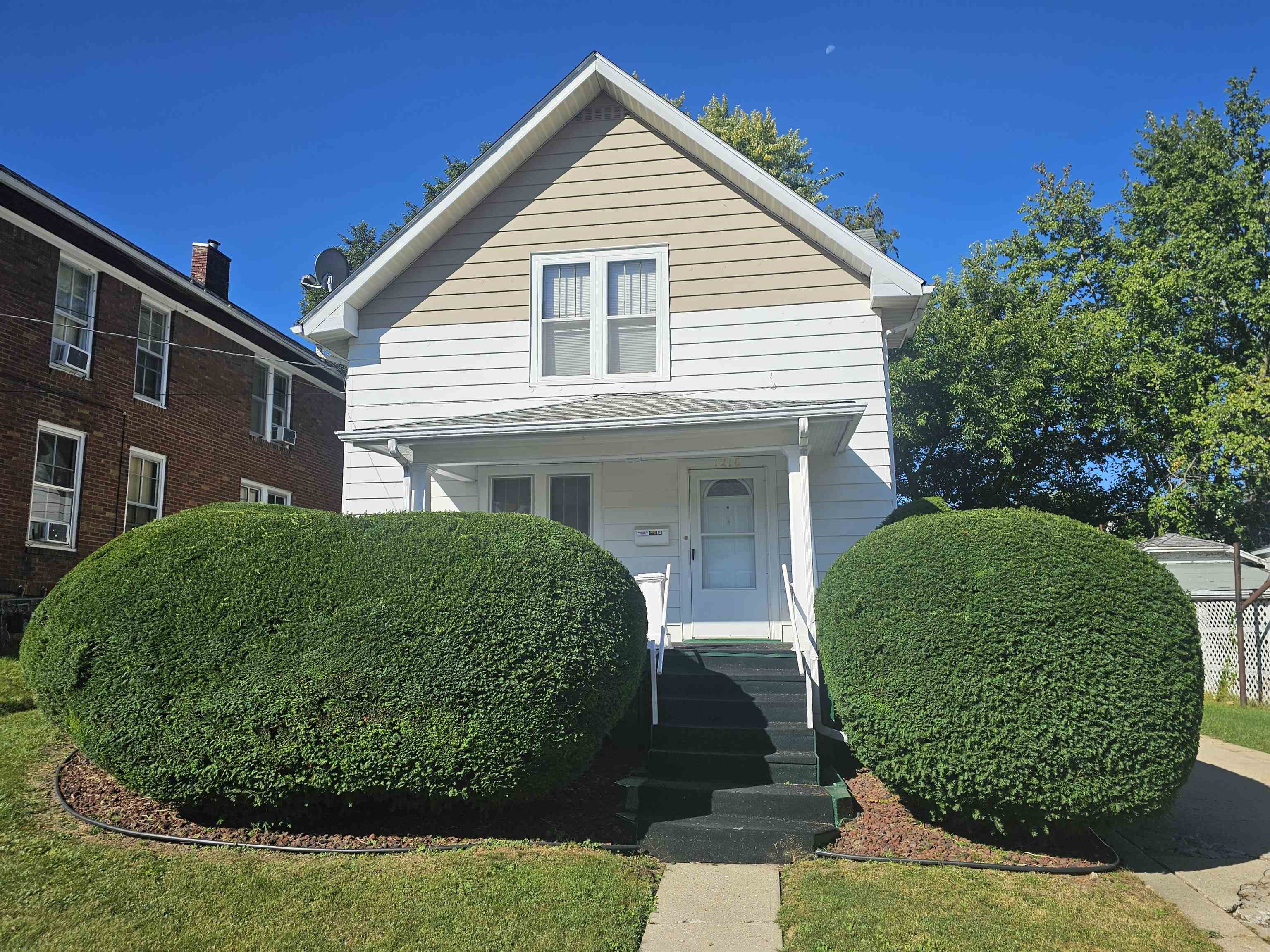 a front view of a house with a garden