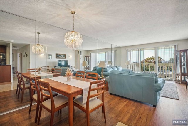 a dining room with wooden floor a chandelier a wooden table and chairs