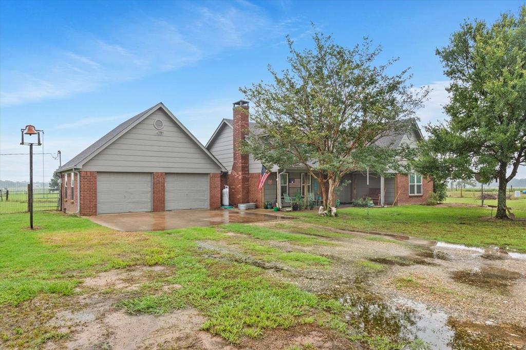 a front view of a house with a yard and trees