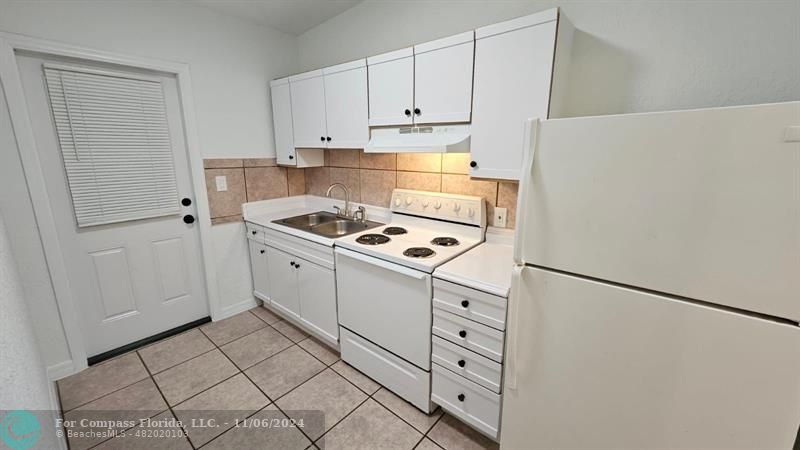 a kitchen with white cabinets and white appliances