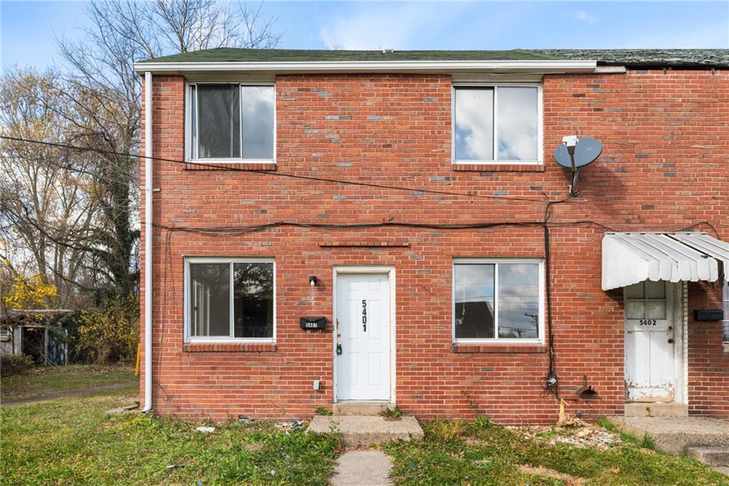 front view of a brick house with a small yard