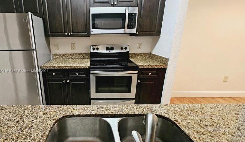 a kitchen with granite countertop a stove and a microwave