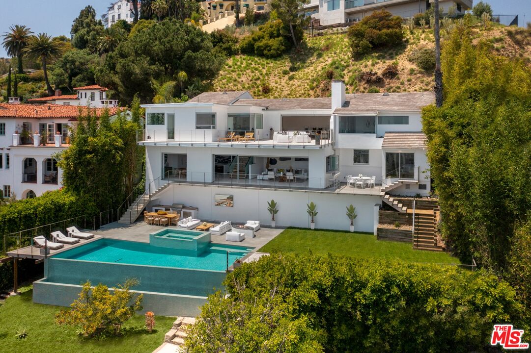 an aerial view of a house with swimming pool garden and patio