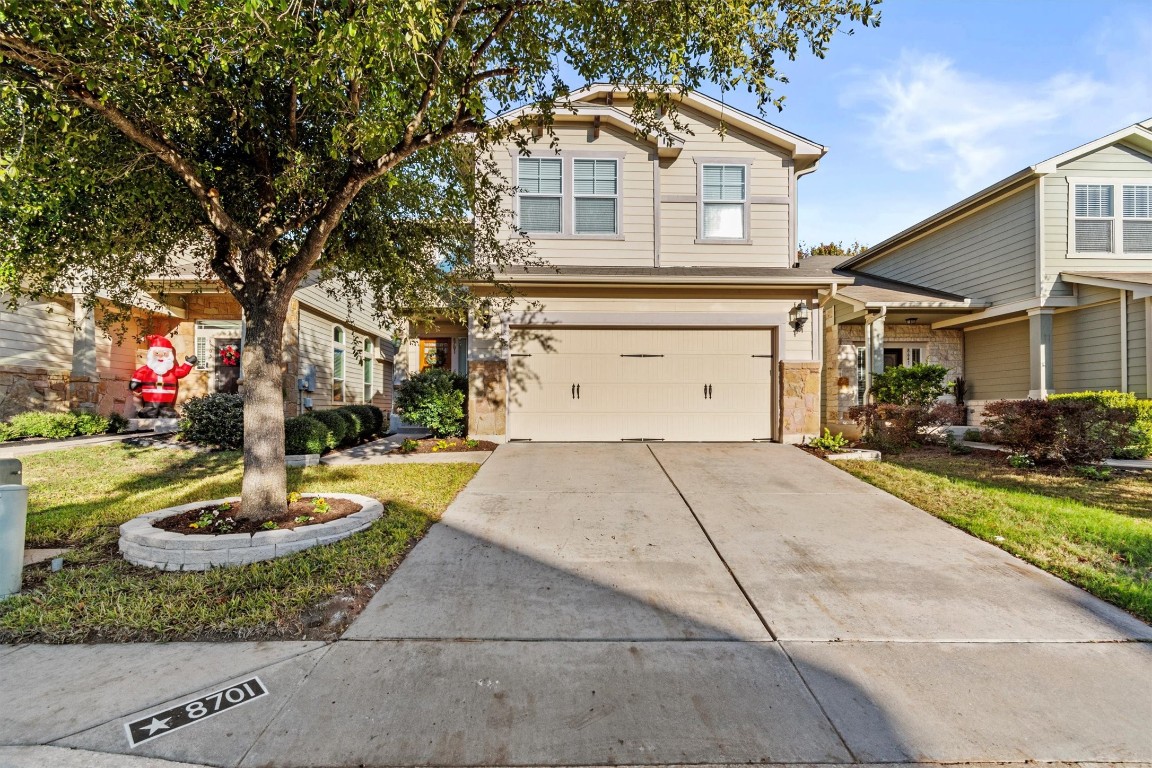 a front view of a house with a yard and a fountain