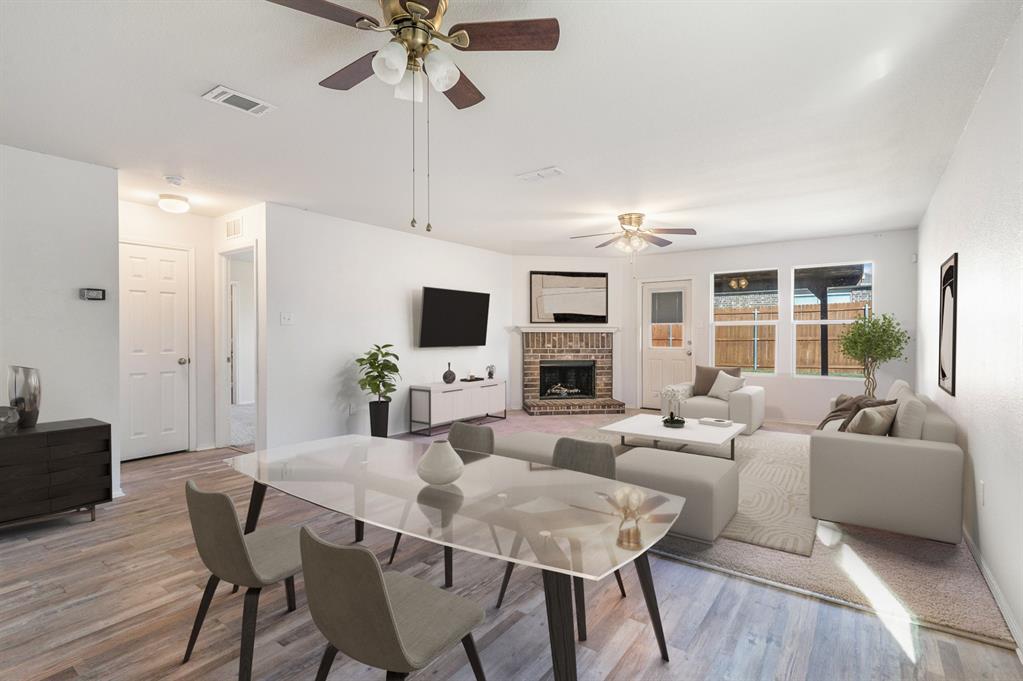 Living room featuring a brick fireplace, ceiling fan, and light hardwood / wood-style flooring