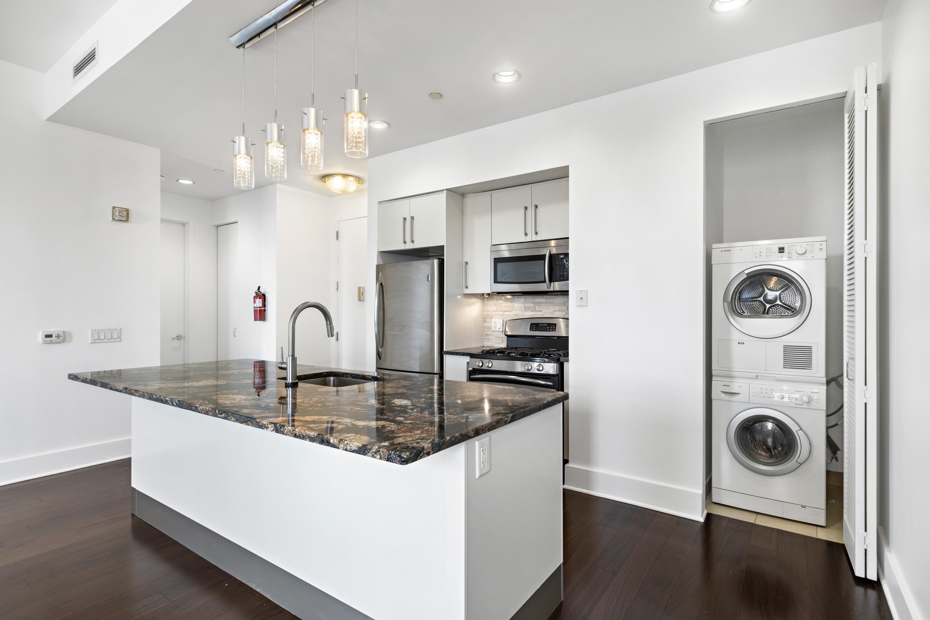 a kitchen with stainless steel appliances granite countertop a sink a stove and refrigerator