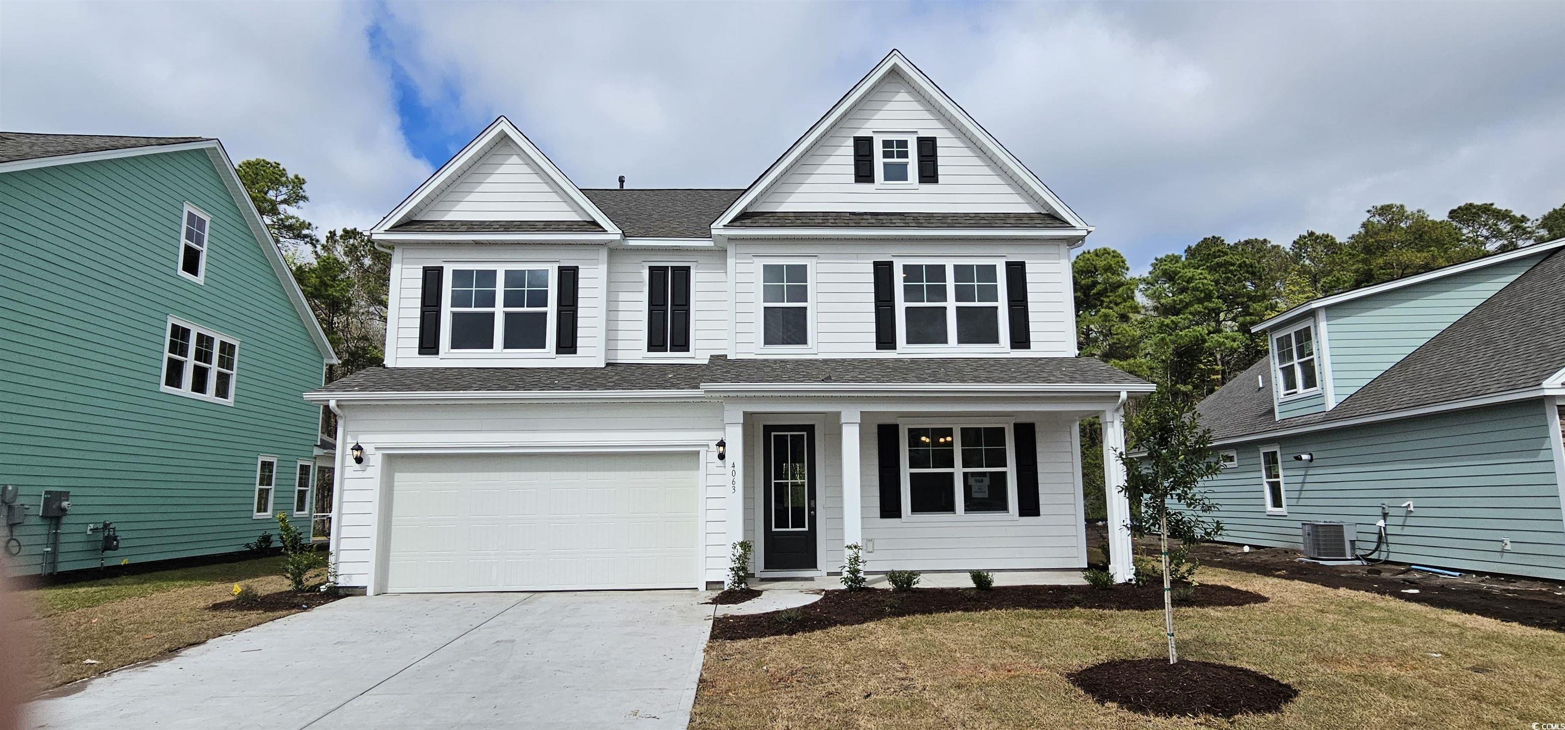 View of front facade with cooling unit, a garage,