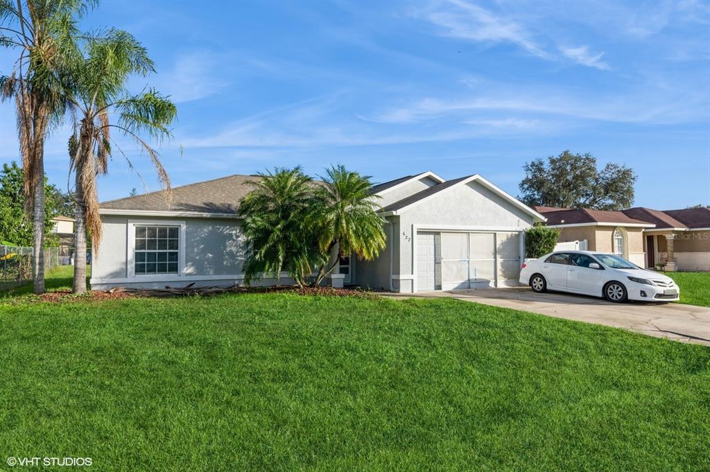 a front view of a house with a garden and palm trees