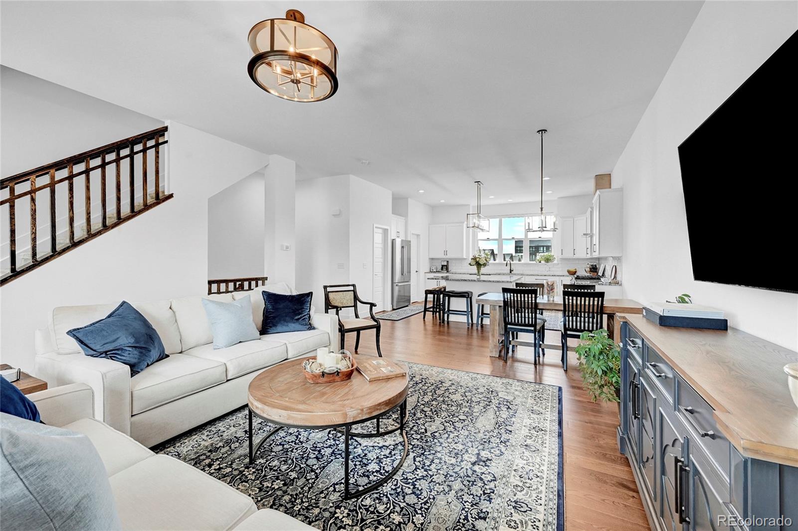 a living room with furniture a flat screen tv and kitchen view