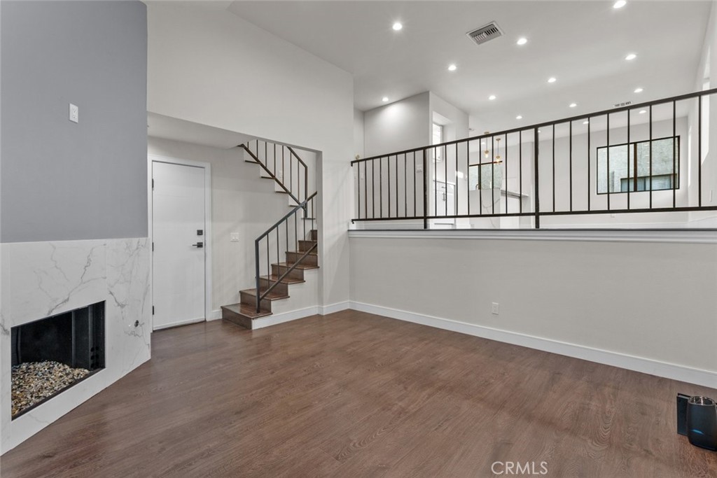 a view of an empty room with stairs and a fireplace