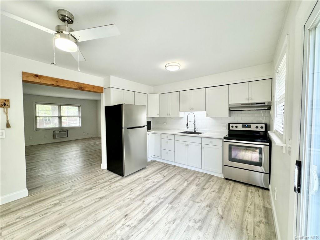 a kitchen with a refrigerator and a stove top oven