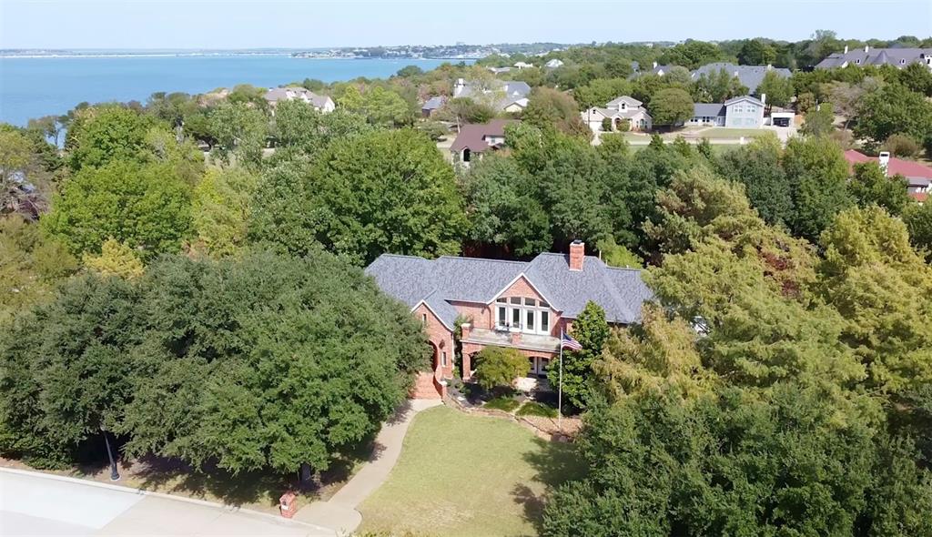 an aerial view of a house with a yard and lake view