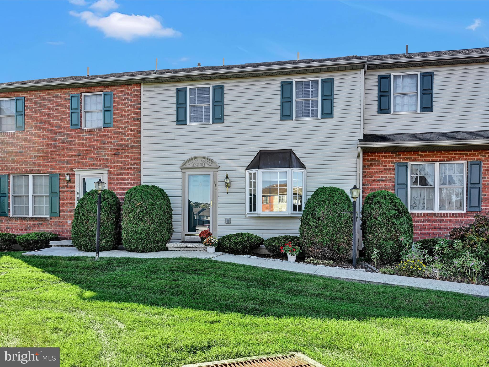 a front view of a house with a yard and plants