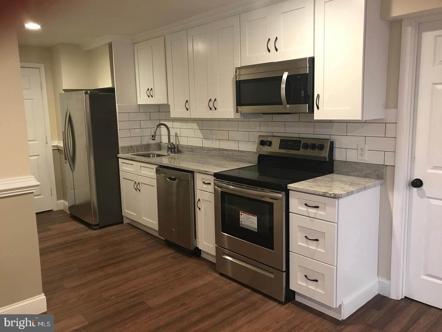 a kitchen with stainless steel appliances a stove microwave and refrigerator