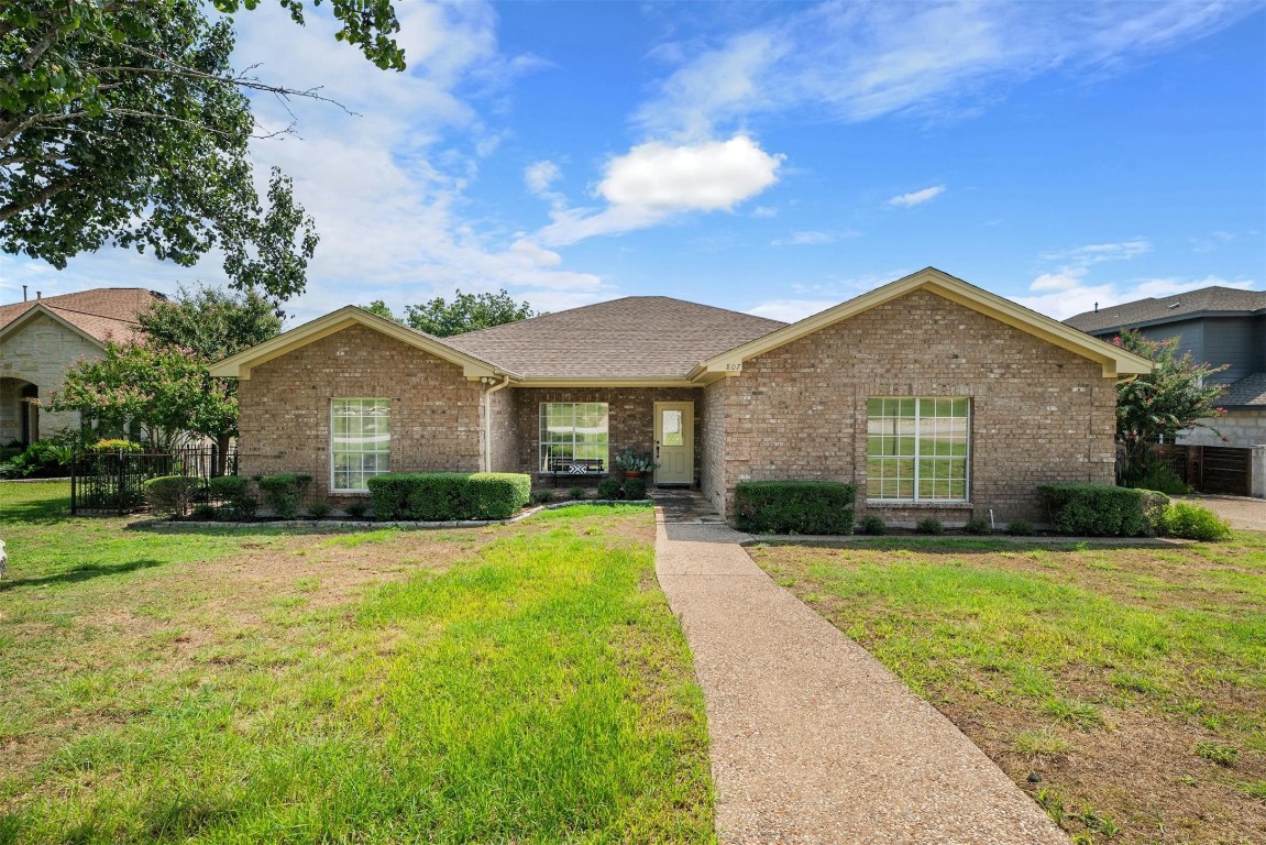 The sprawling layout features a welcoming front patio, a spacious back deck, and a charming pergola in the side yard, all perfect spots for enjoying the peaceful surroundings