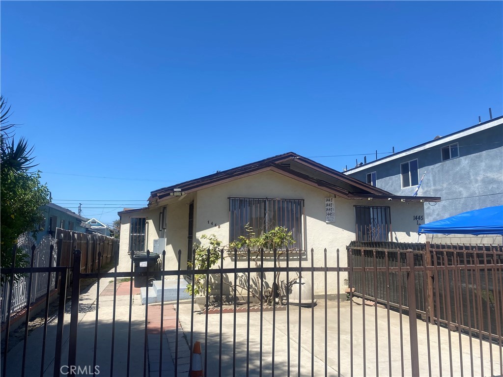 a view of a house with a small yard and wooden fence