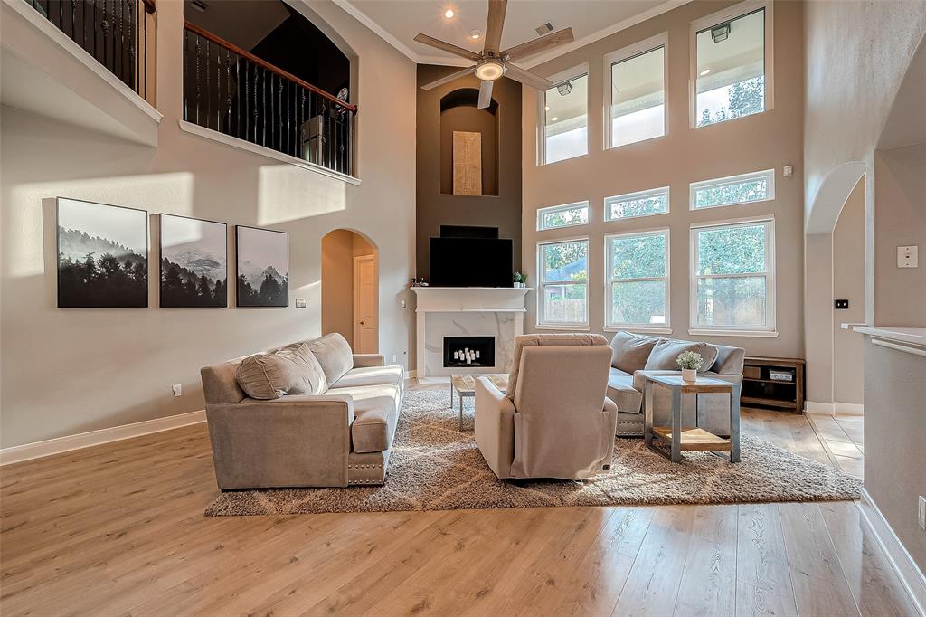 a living room with furniture a fireplace and a floor to ceiling window