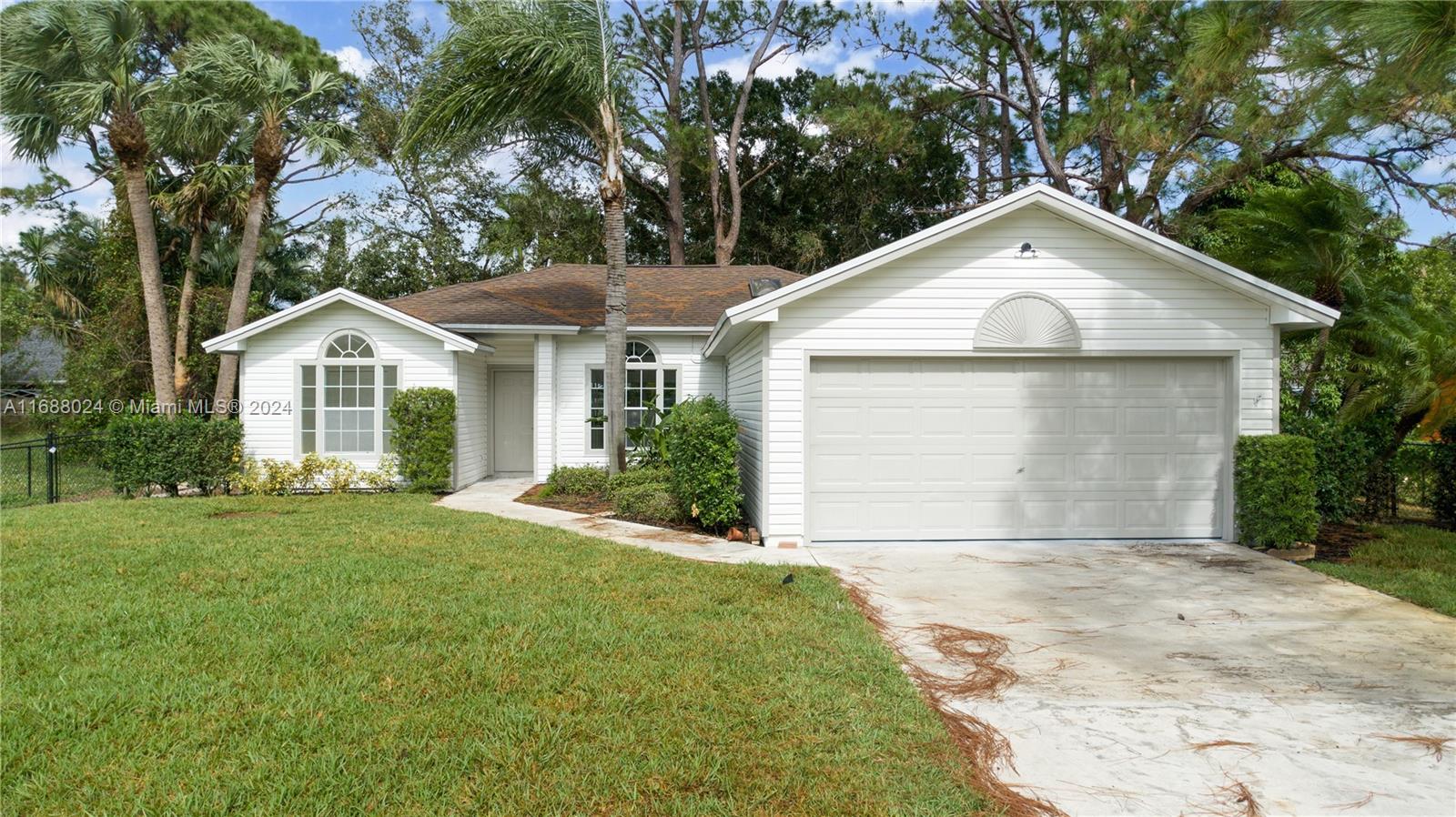 a front view of a house with a garden and yard