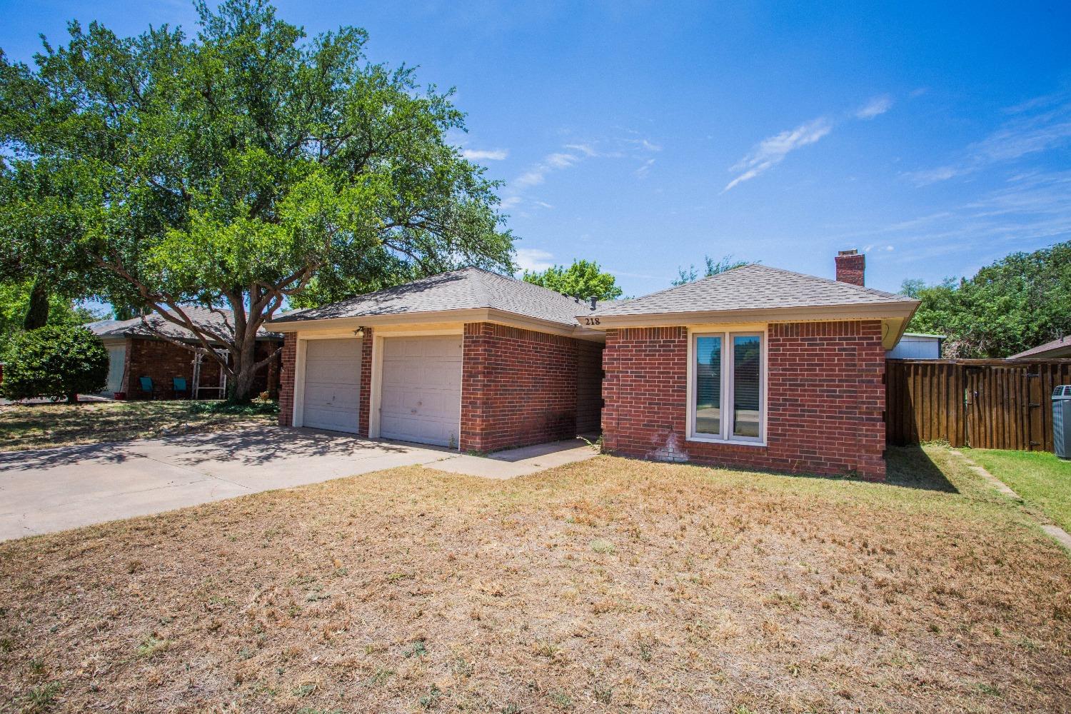 a front view of house with yard and trees in the background