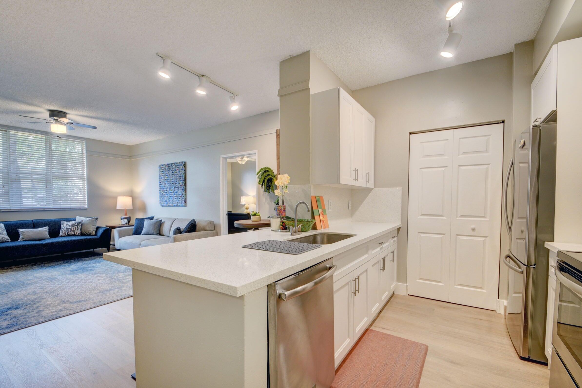 a kitchen that has a sink a stove and chairs