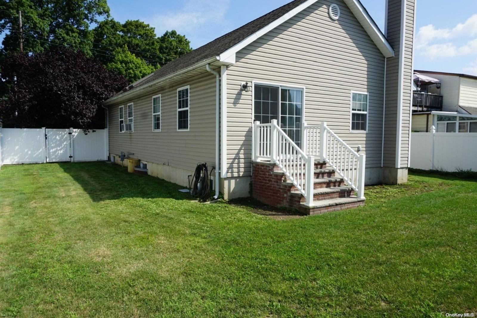 a view of a house with backyard and a tree