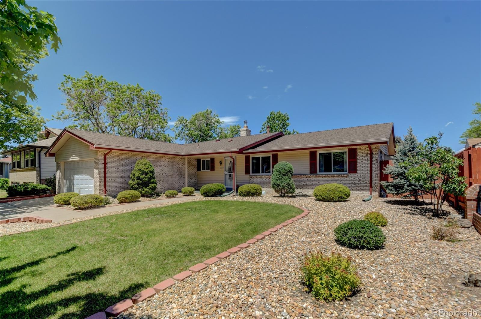 a front view of a house with a yard and potted plants