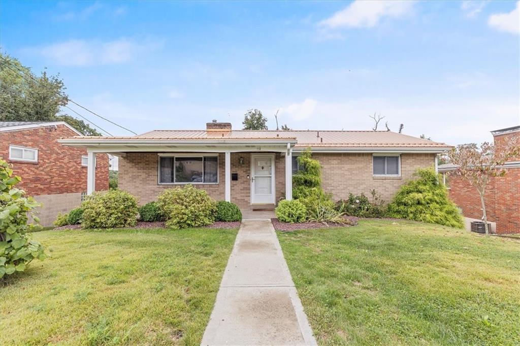 front view of a brick house with a yard