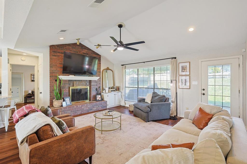 a living room with furniture a fireplace and a flat screen tv