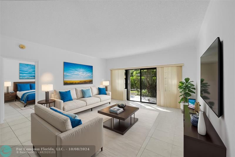 a living room with furniture flat screen tv and a large window