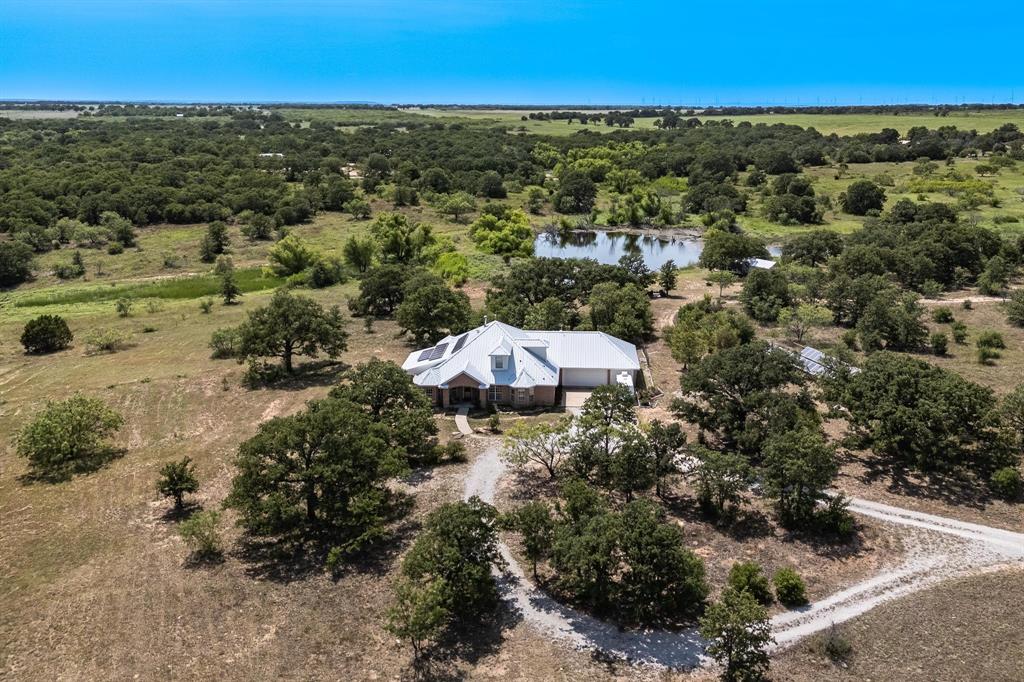 an aerial view of a house with a yard and lake view