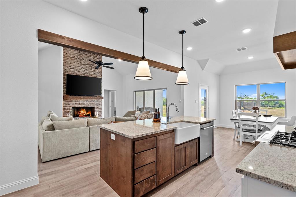 a kitchen with a stove a kitchen island a sink and a flat screen tv