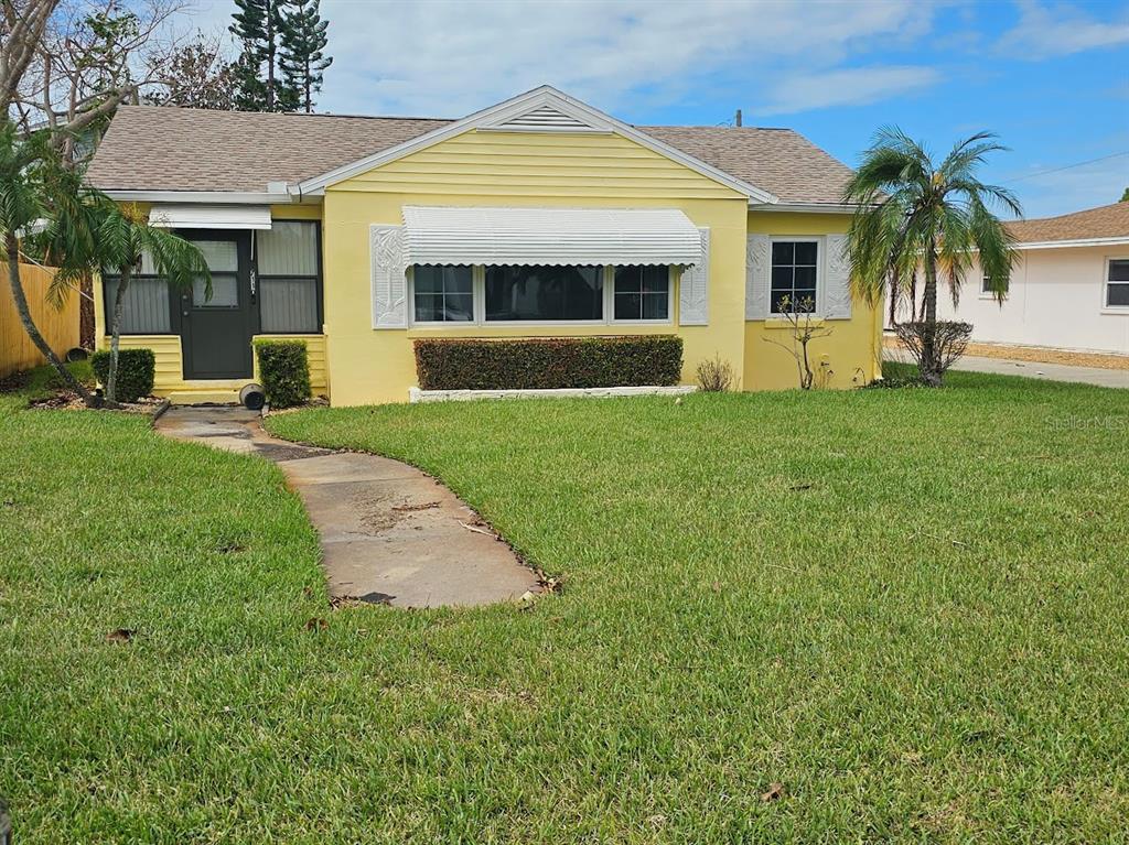 a front view of a house with a yard and potted plants