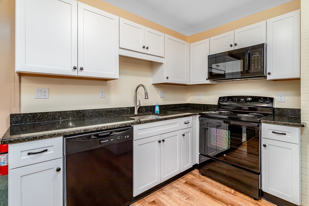 a kitchen with white cabinets and appliances