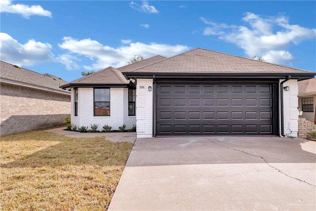 a front view of a house with a yard and garage