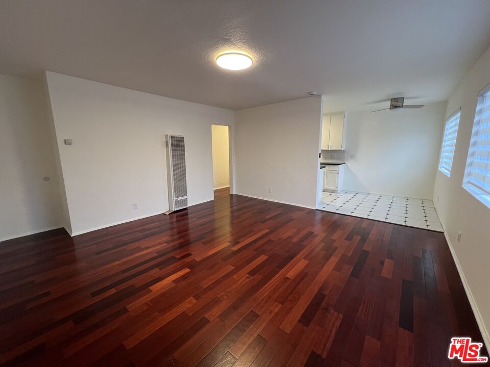 a view of empty room with wooden floor